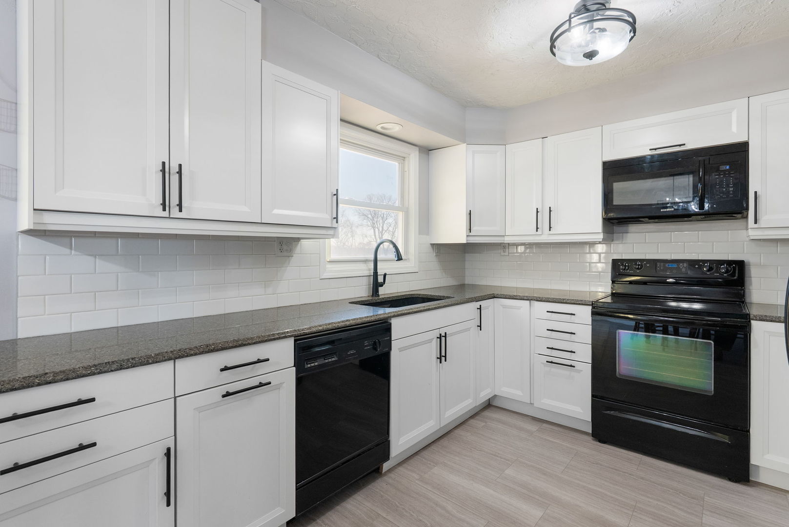 712 Fairfield Road Port Byron, IL 61275 - Photo 9 of 45 a kitchen with stainless steel appliances granite countertop a sink dishwasher a stove and a microwave oven with white cabinets