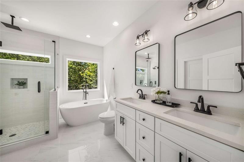 7262 Creekside Way Jefferson, GA 30549 - Photo 30 of 52 a spacious bathroom with a double vanity sink a large mirror and a bathtub