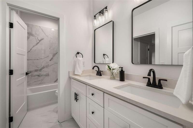 7262 Creekside Way Jefferson, GA 30549 - Photo 35 of 52 a bathroom with a double vanity sink a mirror and a bathtub