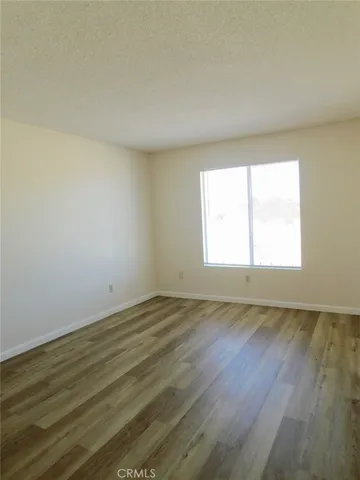an empty room with wooden floor and window