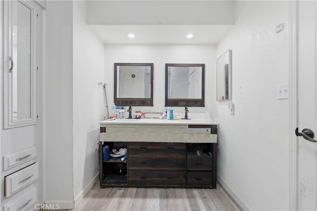 5885 Dos Palmas Road Phelan, CA 92371 - Photo 25 of 40 a bathroom with a sink a mirror and wooden floor