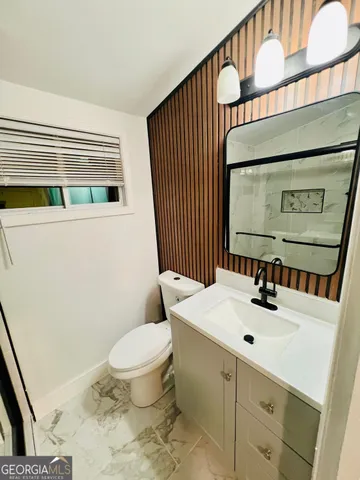 a bathroom with a sink a toilet and mirror