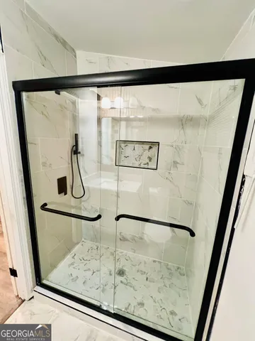 a bathroom with a glass door shower and a sink