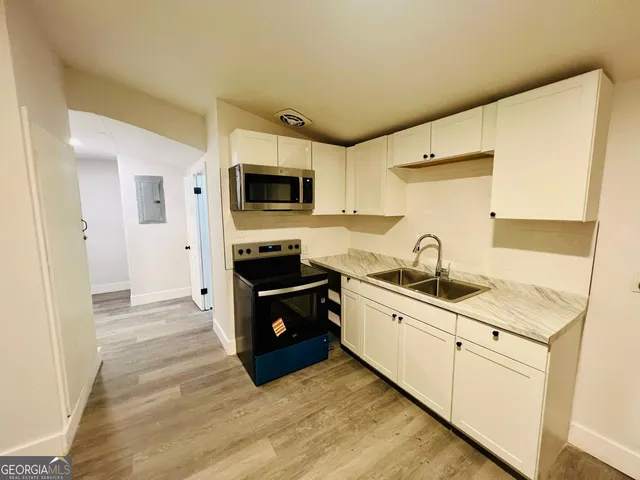 a kitchen with granite countertop a sink and steel appliances