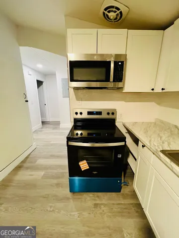 a kitchen with stainless steel appliances granite countertop a stove a microwave and a sink