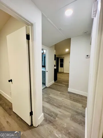a view of a hallway with wooden floor and a cabinet