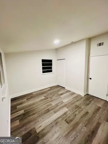 a view of an empty room with wooden floor