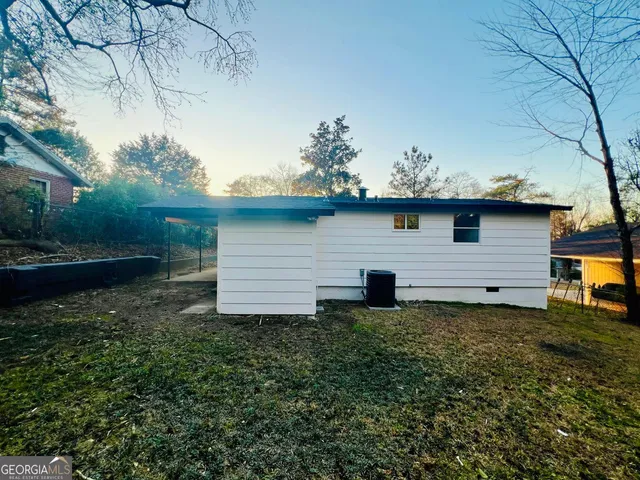 a view of a backyard with plants and large tree