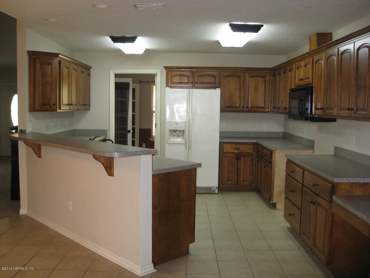 7023 Elfo Road Keystone Heights, FL 32656 - Photo 3 of 12 a kitchen with stainless steel appliances granite countertop a sink counter space cabinets and a large window