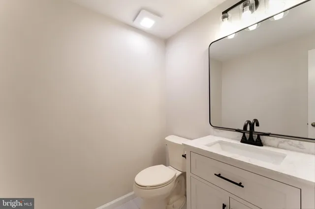a bathroom with a toilet a sink and mirror