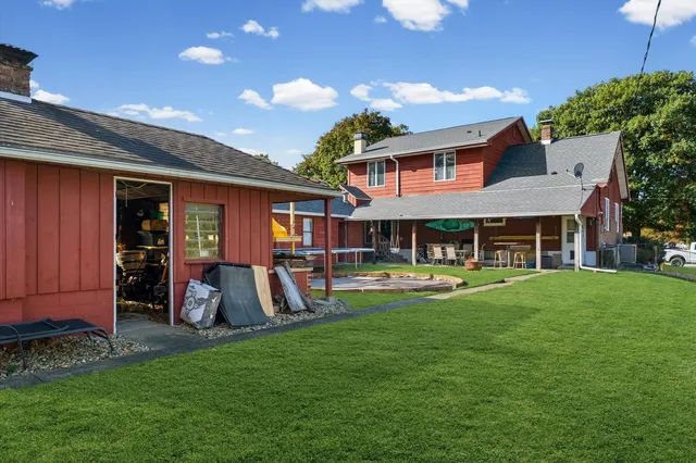 a backyard of a house with barbeque oven table and chairs