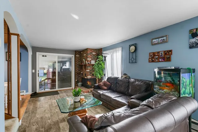 a living room with furniture a flat screen tv and a floor to ceiling window