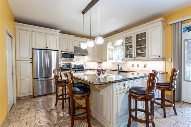 a kitchen with kitchen island granite countertop a sink stove and refrigerator