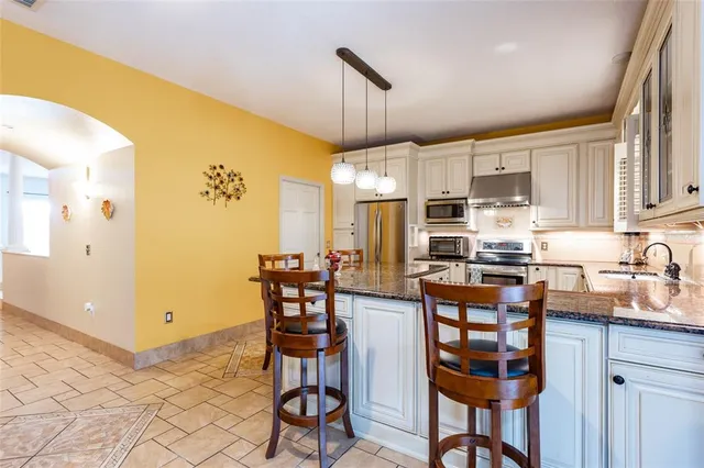 a kitchen with stainless steel appliances a dining table chairs and a refrigerator