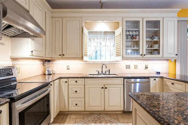 a kitchen with stainless steel appliances granite countertop a sink stove and cabinets
