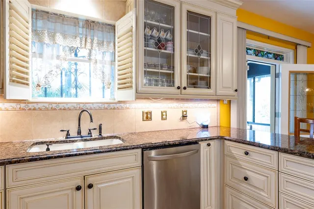 a kitchen with granite countertop stainless steel appliances a sink and cabinets