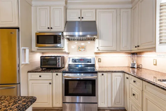 a kitchen with stainless steel appliances a stove a microwave and cabinets