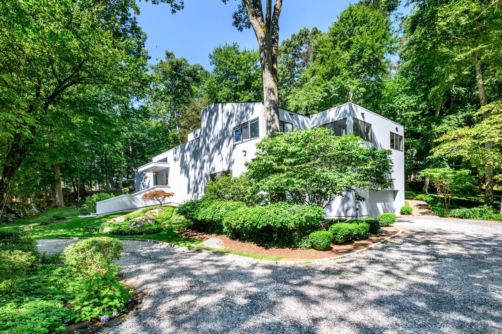 33 Mill Brook Road West Stamford, CT 06902 - Photo 1 of 1 a view of a garden with plants and large trees