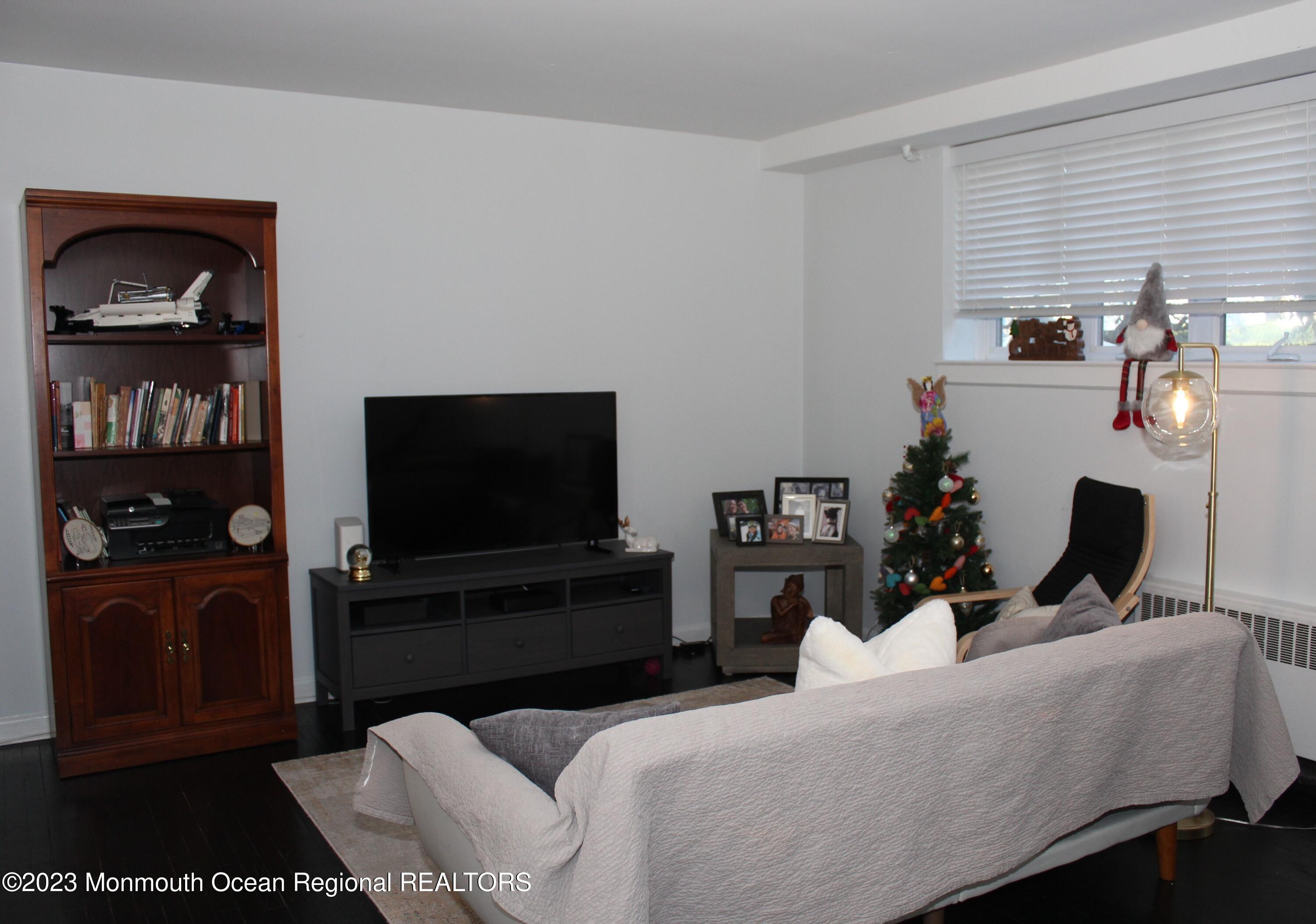 293 Spring Street, Unit 16A Red Bank, NJ 07701 - Photo 3 of 15 a living room with furniture and a flat screen tv