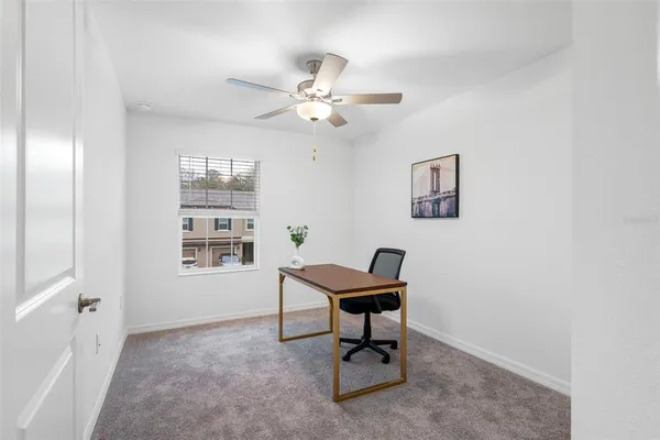 a view of a workspace with furniture and a window