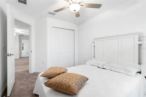 a bedroom with a bed and ceiling fan