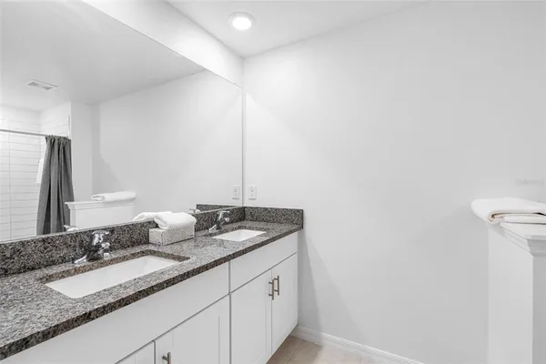 a bathroom with a granite countertop sink and a mirror
