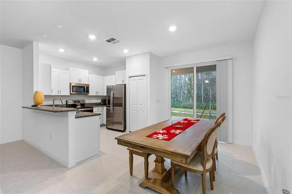 a kitchen with a refrigerator a stove top oven a sink dishwasher and white cabinets with wooden floor