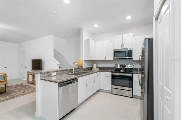 a kitchen with stainless steel appliances granite countertop a stove a sink and a refrigerator