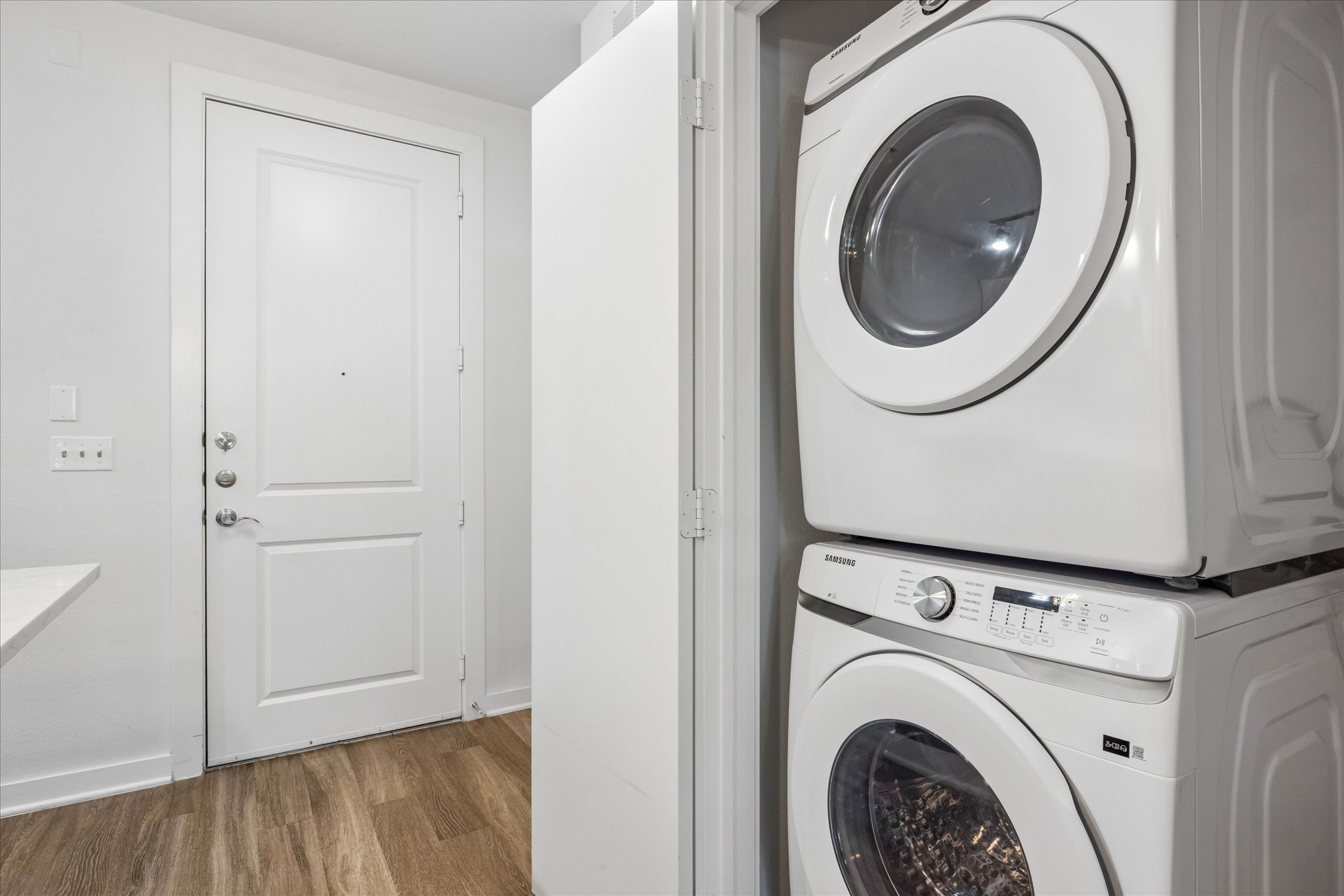 1900 Barton Springs Road, Unit 4041 Austin, TX 78704 - Photo 25 of 35 Stacked laundry appliances and wood-style flooring streamline daily tasks in this functional area.
