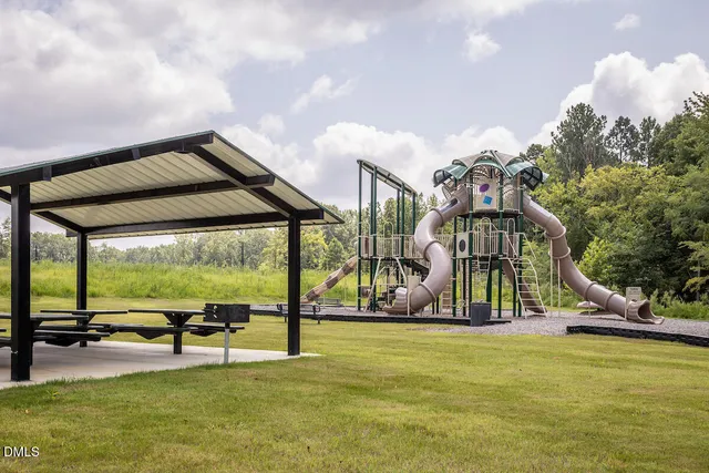 a view of swimming pool with lawn chairs and iron fence