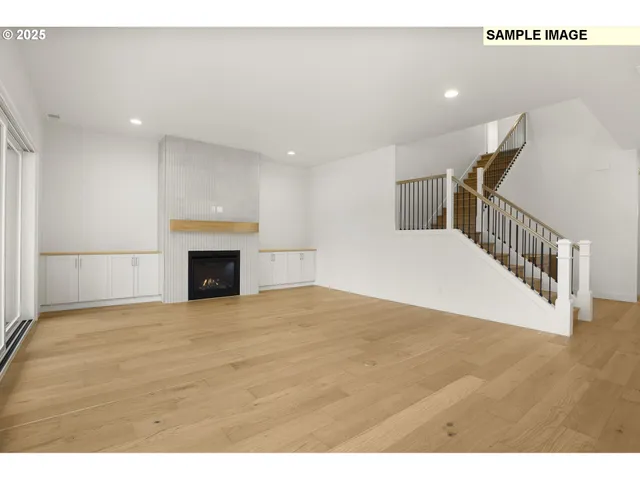 a view of empty room with wooden floor and fireplace