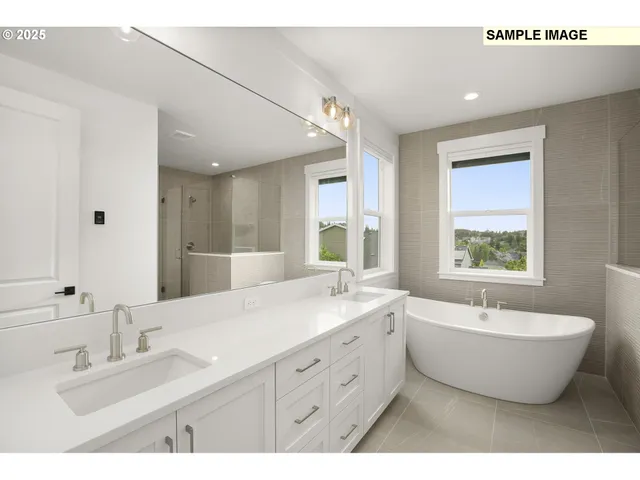 a spacious bathroom with a double vanity sink a mirror and a bathtub