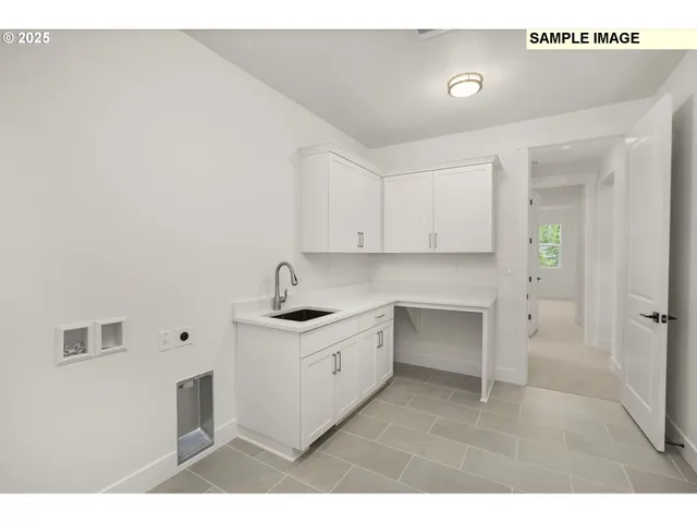 a kitchen with white cabinets and sink