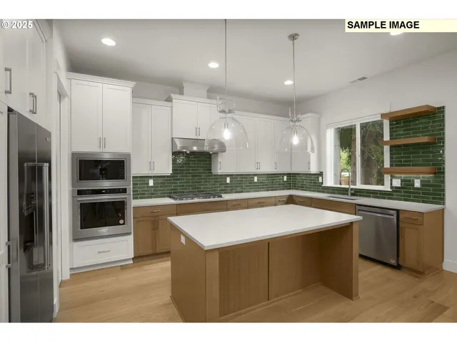 a kitchen with stainless steel appliances granite countertop a sink a stove and a refrigerator