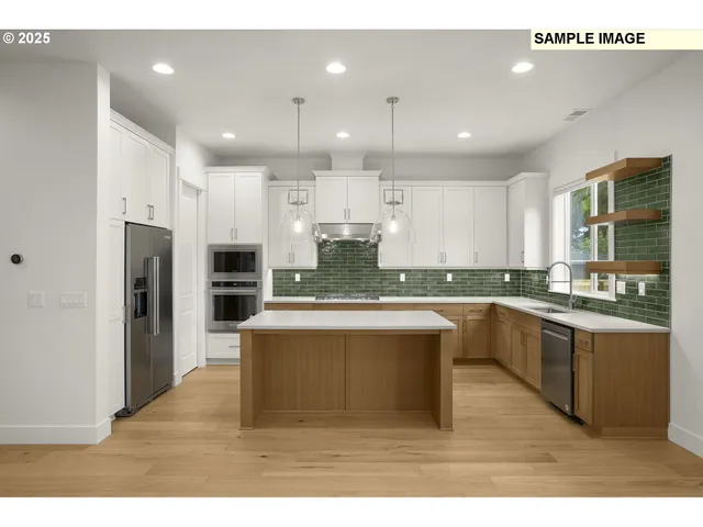 a large kitchen with granite countertop a large counter top stainless steel appliances and cabinets