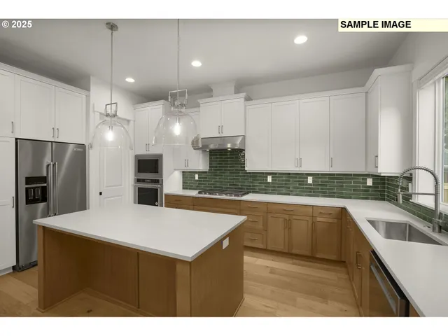 a kitchen with kitchen island a sink stainless steel appliances and cabinets