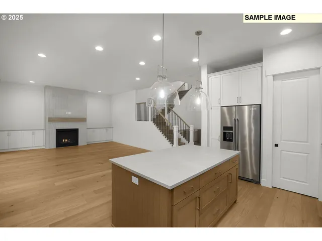 a kitchen with kitchen island a sink stainless steel appliances and a counter top space