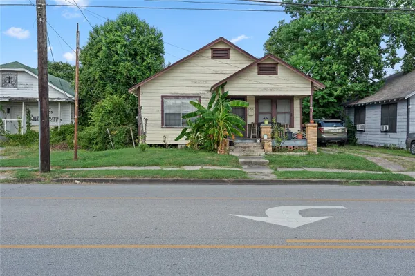 a front view of a house with a yard and potted plants