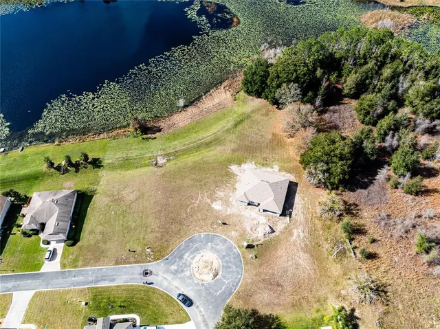 an aerial view of a house with a yard swimming pool and outdoor seating