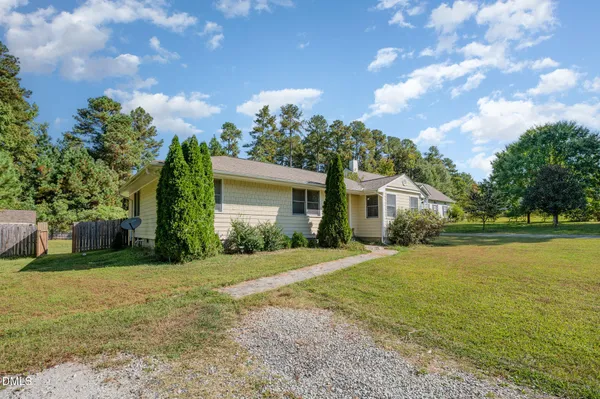 a front view of a house with a yard and trees