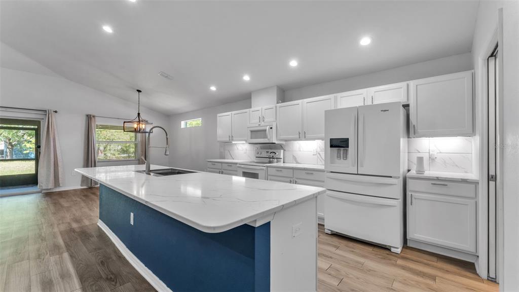 501 Interlock Street Lake Alfred, FL 33850 - Photo 14 of 49 a kitchen with kitchen island a sink stove and refrigerator