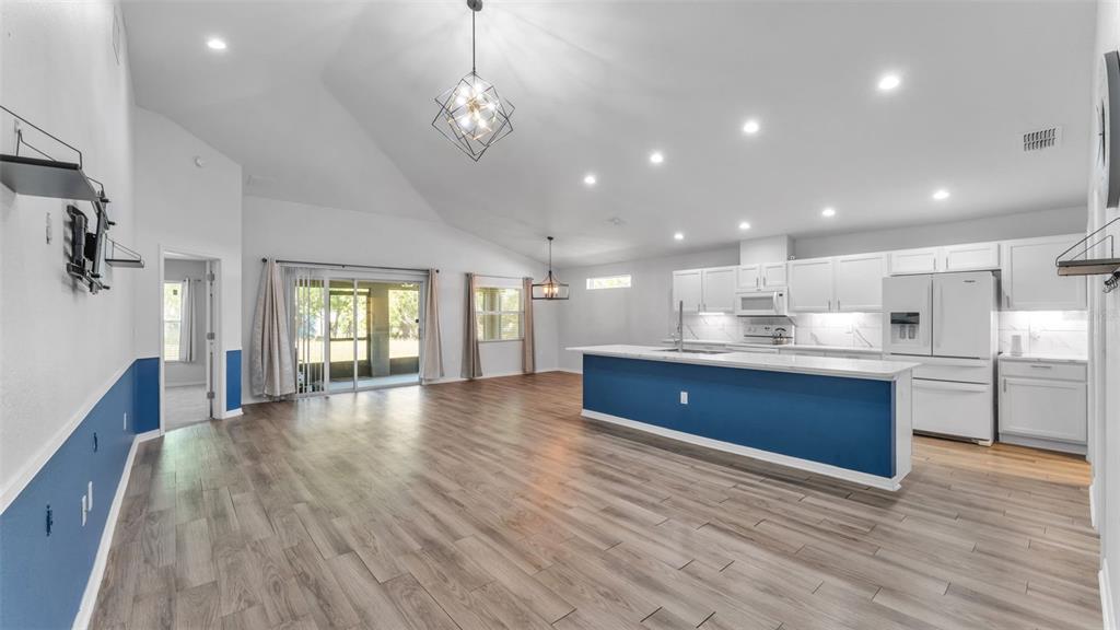 501 Interlock Street Lake Alfred, FL 33850 - Photo 15 of 49 a room with stainless steel appliances granite countertop wooden floors a large window and a fireplace