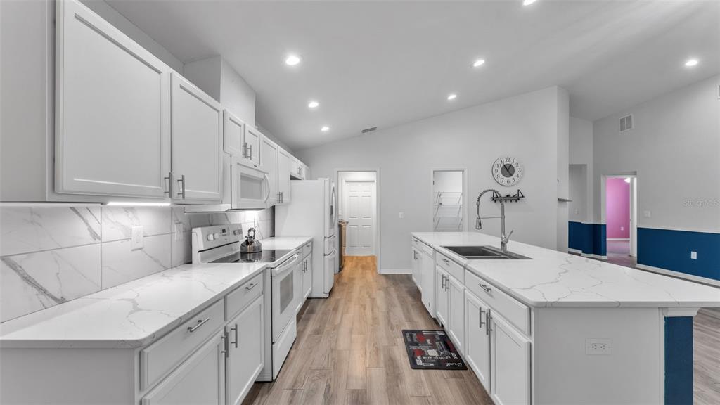 501 Interlock Street Lake Alfred, FL 33850 - Photo 19 of 49 a large white kitchen with stainless steel appliances