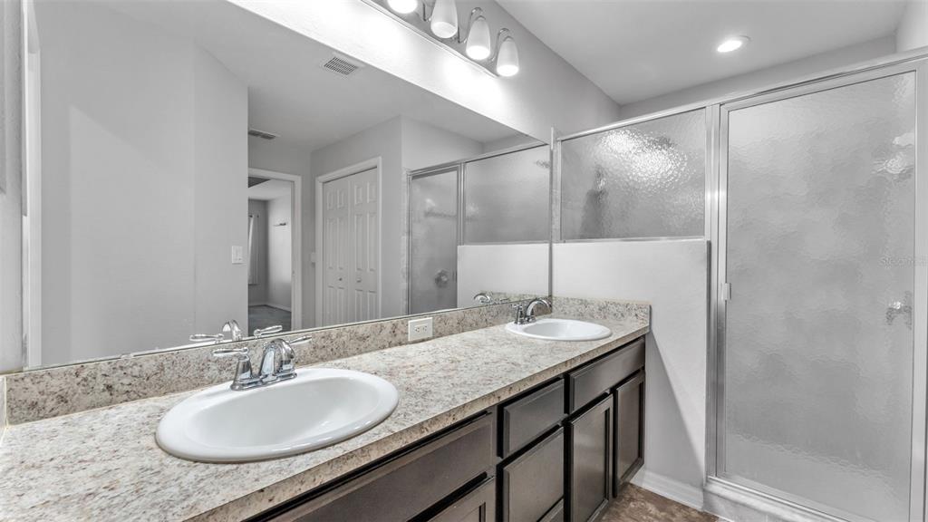 501 Interlock Street Lake Alfred, FL 33850 - Photo 29 of 49 a bathroom with a granite countertop sink a mirror and a shower