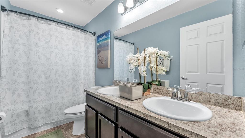 501 Interlock Street Lake Alfred, FL 33850 - Photo 35 of 49 a bathroom with a granite countertop sink a toilet and a mirror