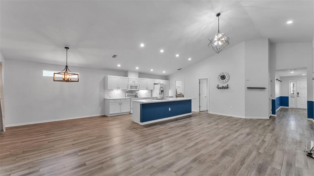 501 Interlock Street Lake Alfred, FL 33850 - Photo 9 of 49 a large kitchen with stainless steel appliances granite countertop a large kitchen island a hardwood floor and a sink