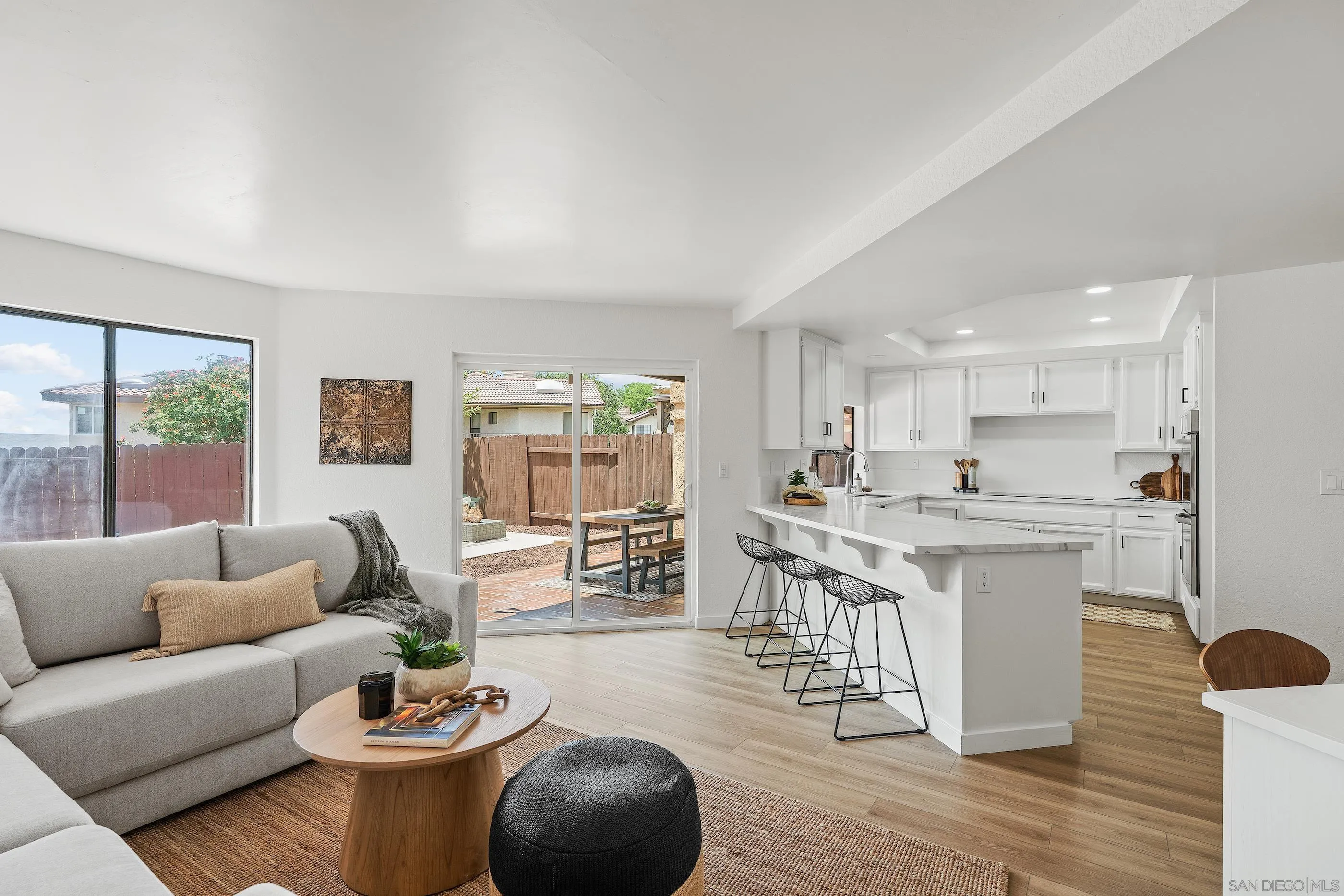 10015 Vallata Court Spring Valley, CA 91977 - Photo 6 of 33 a living room with stainless steel appliances granite countertop a couch wooden floor and a large window