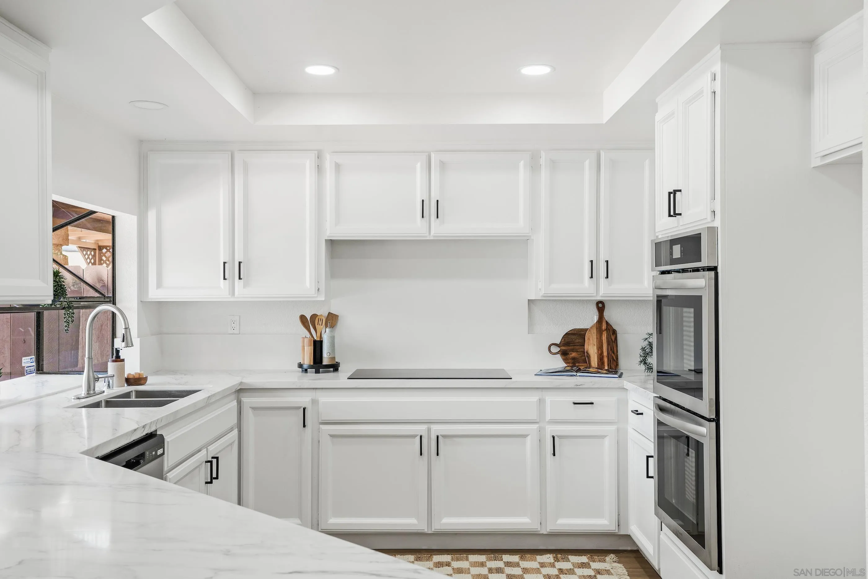 10015 Vallata Court Spring Valley, CA 91977 - Photo 8 of 33 a kitchen with white cabinets and appliances