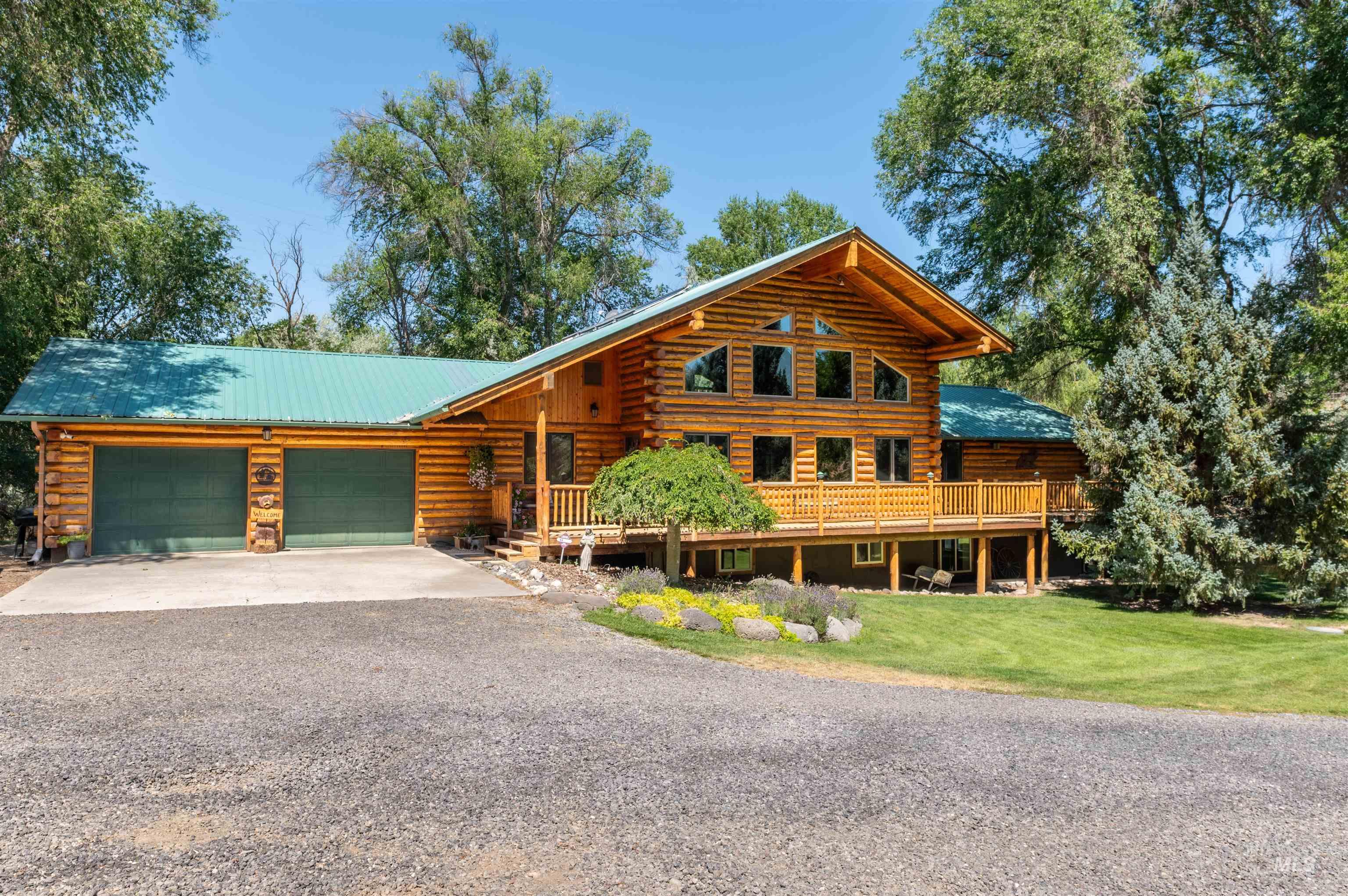 1314 River Road Buhl, ID 83316 - Photo 1 of 45 Cabin featuring log exterior, gravel driveway, an attached garage, a front lawn, and a metal roof