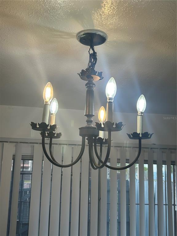 4031 Henley Road, Unit 1706 Orlando, FL 32839 - Photo 11 of 41 a room with a chandelier a light fixture a fireplace and a chandelier